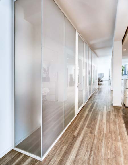 Schaltbares Glas trennt einen Besprechungsraum im Büro von den restlichen Räumlichkeiten
